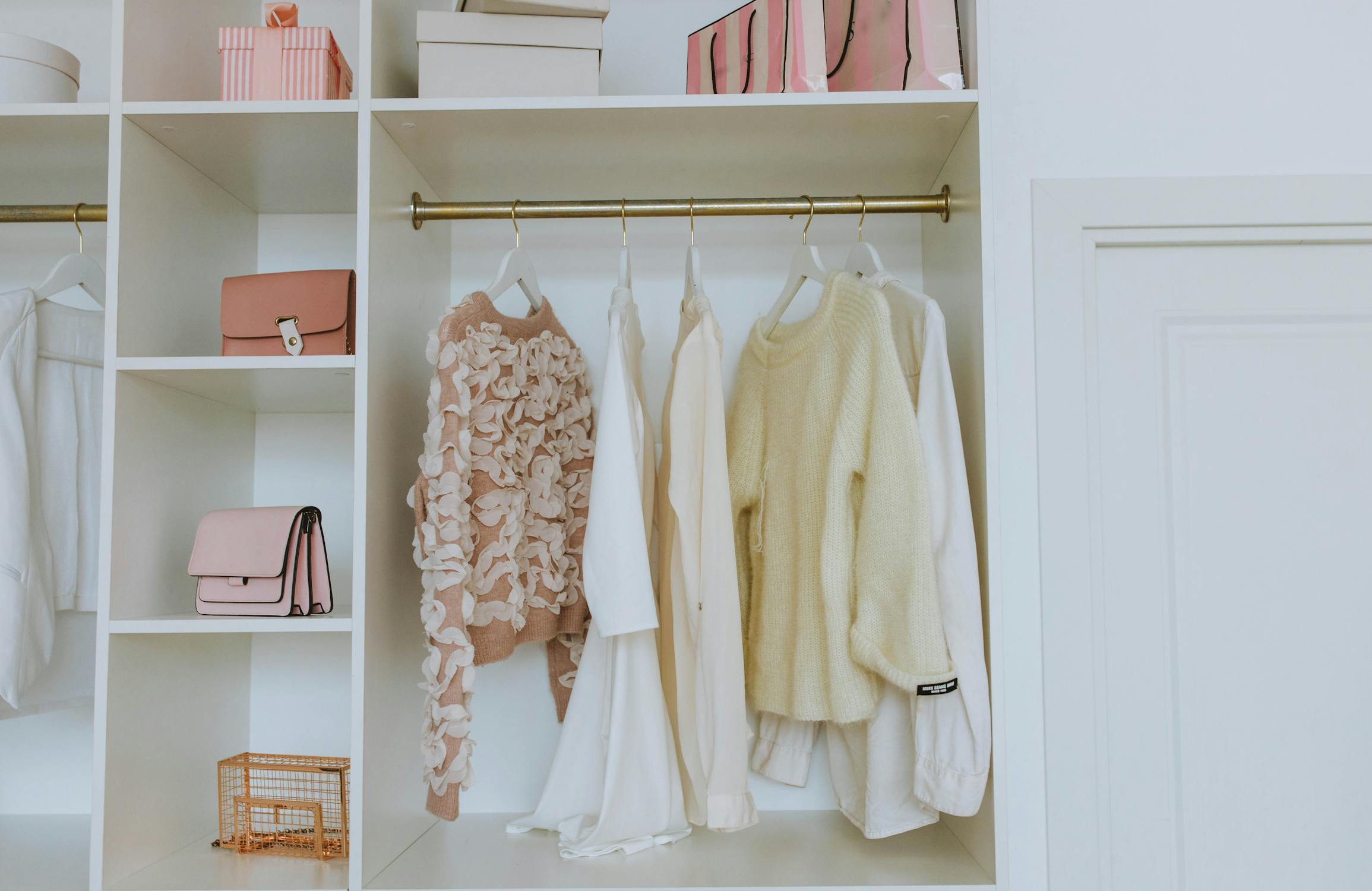 Timeless wardrobe pieces neatly organized in soft neutral colors