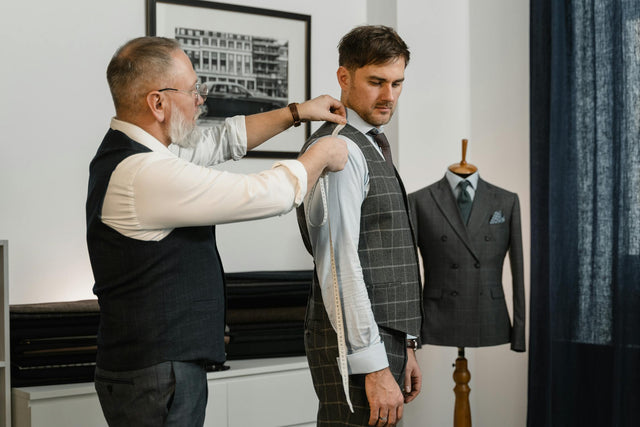 Tailor measuring child using tape measure for sizing up clothes