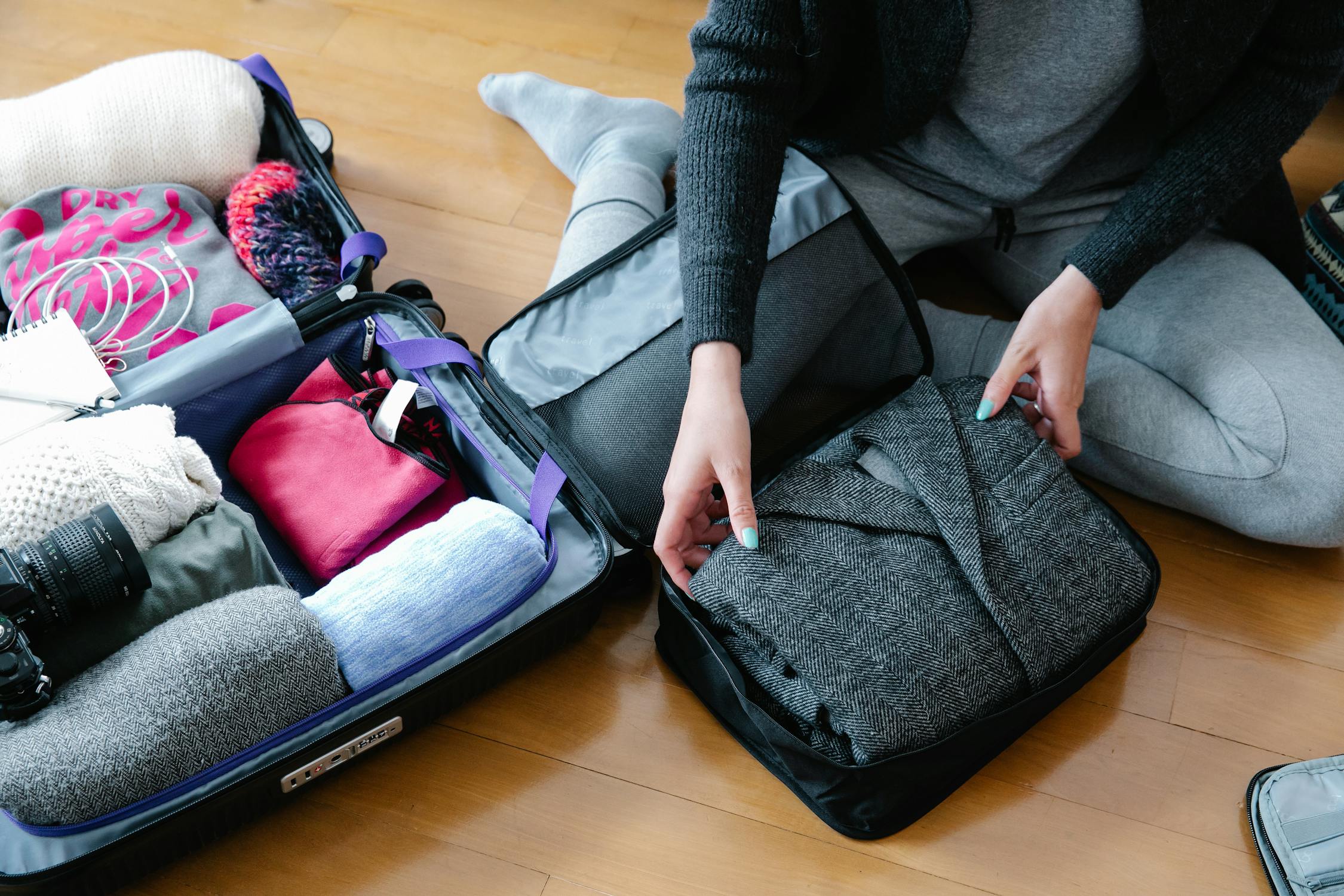 Person organizing packed clothes and budget planning for kids wardrobe